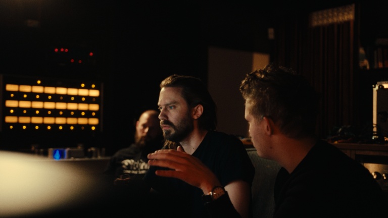 Bildet viser Kristoffer Lo sittende i et mørkt studio, han sitter dypt konsentrert om musikken han er i ferd med å produsere.